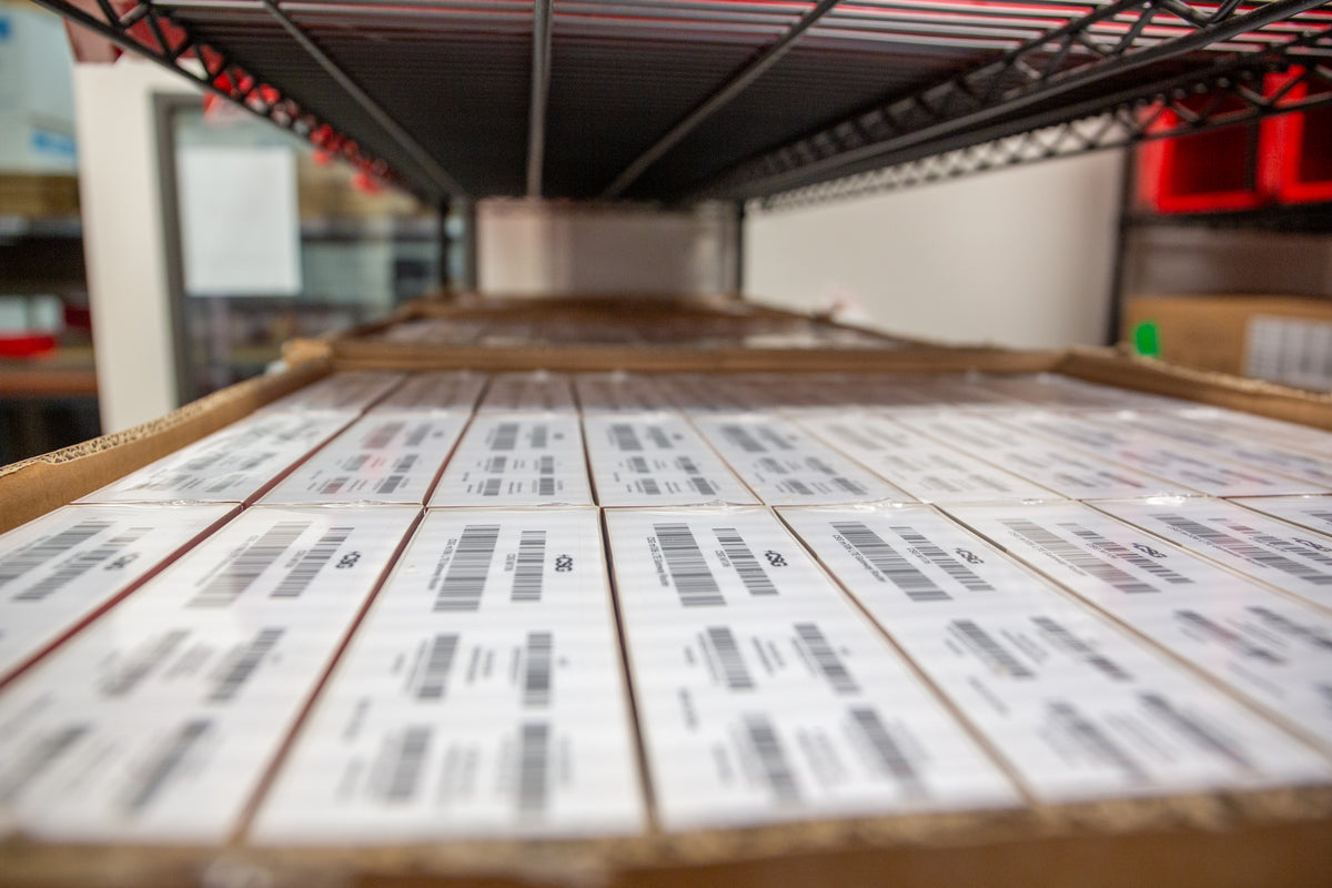 Stacks of labeled boxes on a shelf in a warehouse setting